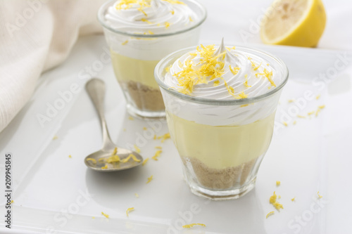 Layered dessert with lemon cream, ice cream and whipped cream