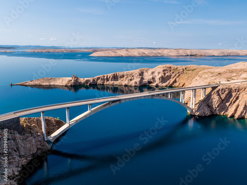 Fototapeta Naklejka Na Ścianę i Meble -  Bridge road to island Pag, Pag is a Croatian island in the Adriatic Sea. It’s known for its barren, moonlike landscape, lace production and Pag cheese. Pebble and sand beaches ring the island, drone