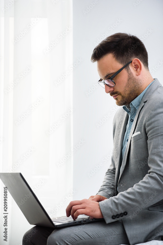 Businessman using laptop computer, working at his hotel room. Traveling for work. Businessman using laptop computer, working at his hotel room. Traveling for work.