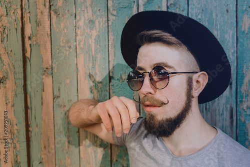 Fashion portrait of young stylish hipster man in hat and sunglasses. Youth, fashion and personal style concept © Vadym