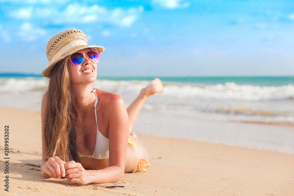 woman in bikini and straw hat lying on tropical beach woman in bikini and straw hat lying on tropical beach