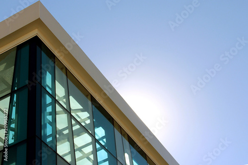 the transparent facade of the building against the sky and the sun