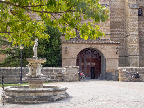 Two cycling pilgrims stop by the parish church dedicated to Our Lady of the Assumption - Villatuerta, Navarre, Spain photo