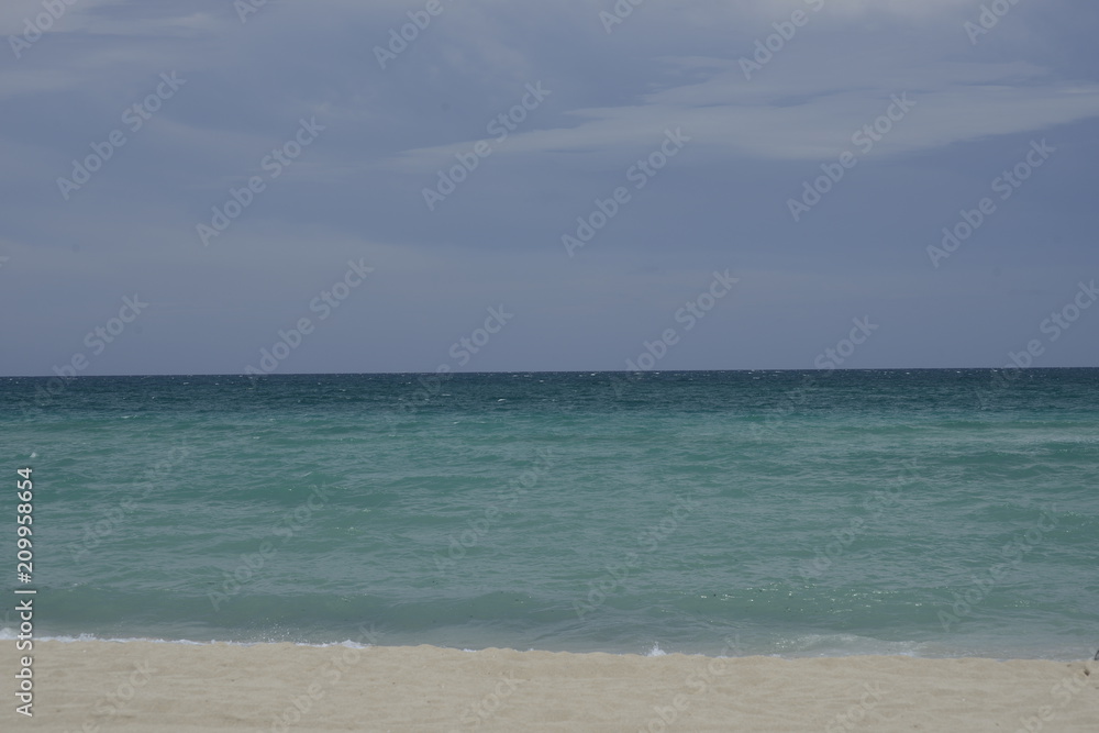 Sea all the way to horizon on sunny blue day sand beach