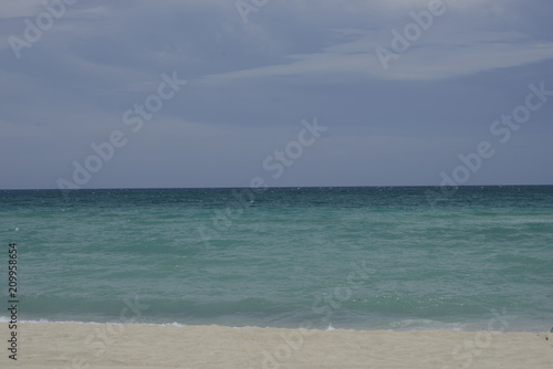 Sea all the way to horizon on sunny blue day sand beach