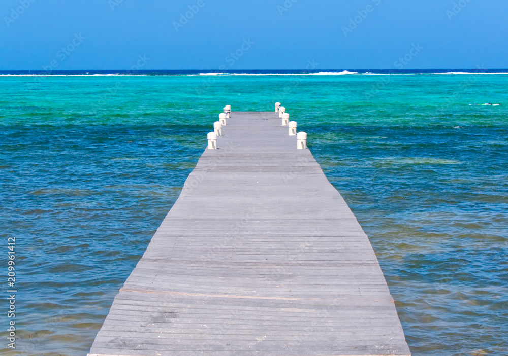 Wood boardwalk pier leading to the ocean, relaxing, calm view and spot Wood boardwalk pier leading to the ocean, relaxing, calm view and spot