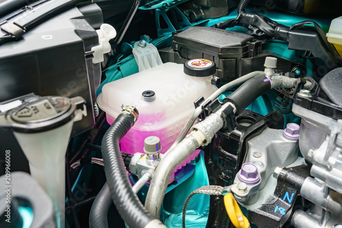 Close view of an engine coolant tankof a serviced car photo