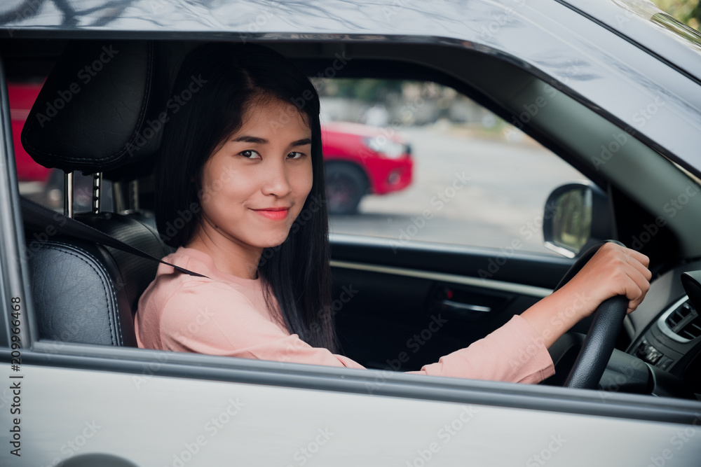 Portrait of woman  is smiling while driving a car.