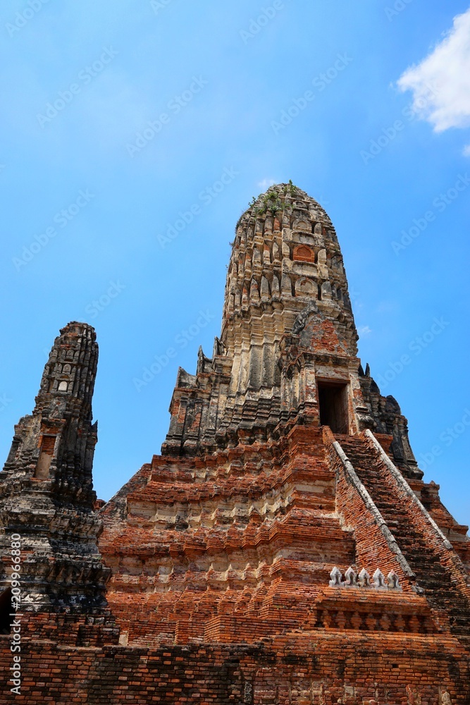 Travel Thailand - Pagoda in Wat Chaiwatthanaram on blue sky and cloud background, Ayutthaya Historical Park. The brick pagoda at old ayutthaya temple ruins. Space for text in template.