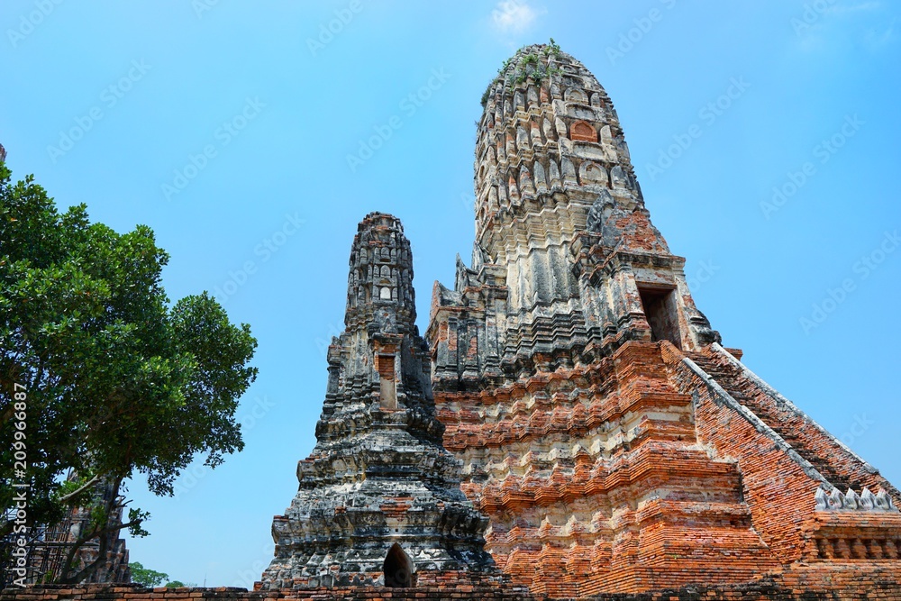 Travel Thailand - Pagoda in Wat Chaiwatthanaram on blue sky and cloud background, Ayutthaya Historical Park. The brick pagoda at old ayutthaya temple ruins. Space for text in template. Travel Thailand - Pagoda in Wat Chaiwatthanaram on blue sky and cloud background, Ayutthaya Historical Park. The brick pagoda at old ayutthaya temple ruins. Space for text in template.