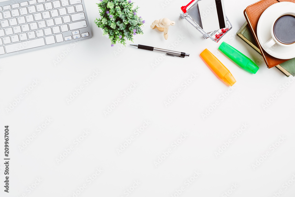 View from above.Keyboard,pen,credit card,notebook and cup of coffee on white office desk with copy space. View from above.Keyboard,pen,credit card,notebook and cup of coffee on white office desk with copy space.