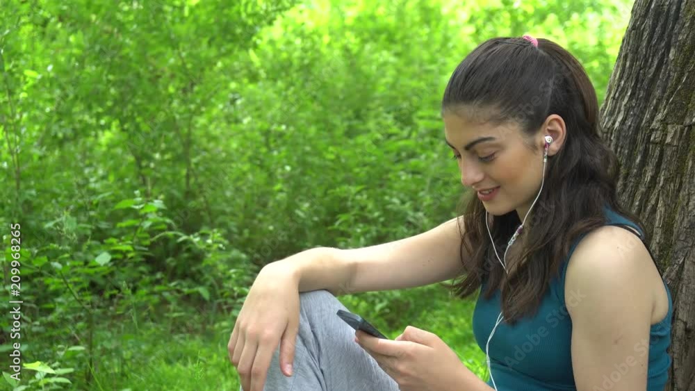 Beautifull sports girl with the phone in the park Beautifull sports girl with the phone in the park
