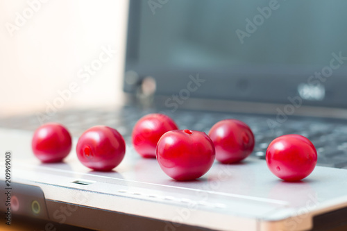 Ripe berries on a laptop. A break for food while working in the office. Useful and delicious food. Vitamins for health_