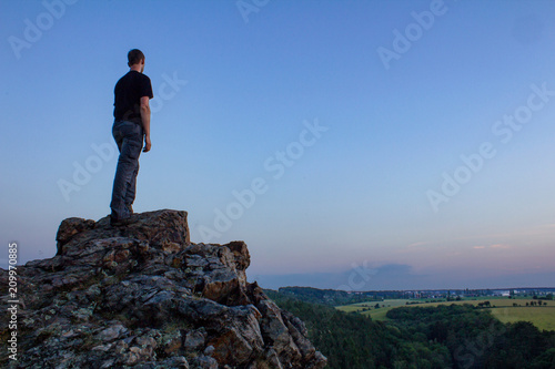 Young man stand on rock on Ales lookout  Czech landscape  blue hour