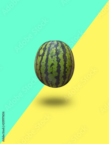 Watermelon isolated on a blue green and yellow background with a shadow