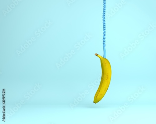 Single banana headphone of a hanging on light blue color background. minimal idea food and fruit