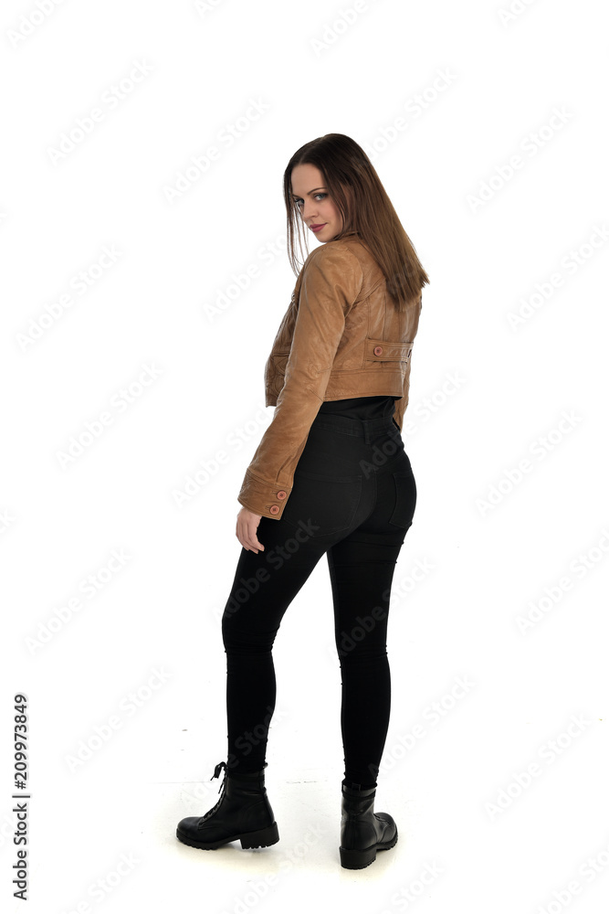 full length portrait of brunette girl wearing brown leather jacket. standing pose with back to the camera on white background. full length portrait of brunette girl wearing brown leather jacket. standing pose with back to the camera on white background.