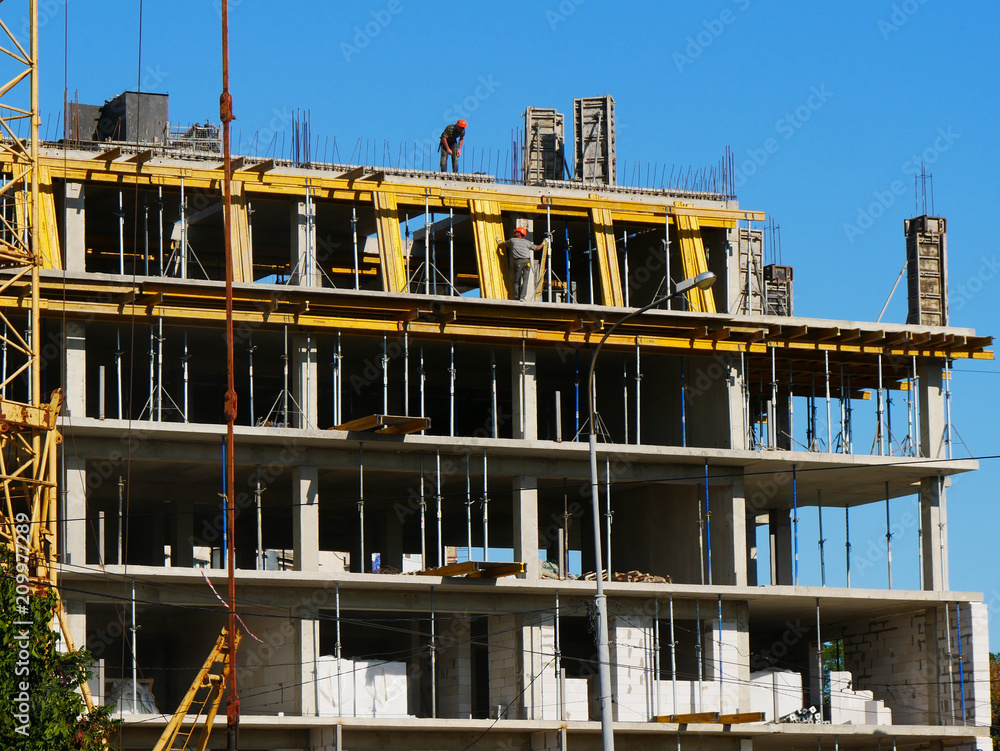Building under construction against blue sky. Construction site.
