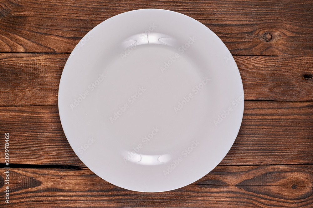 pure white plate on wooden background pure white plate on wooden background