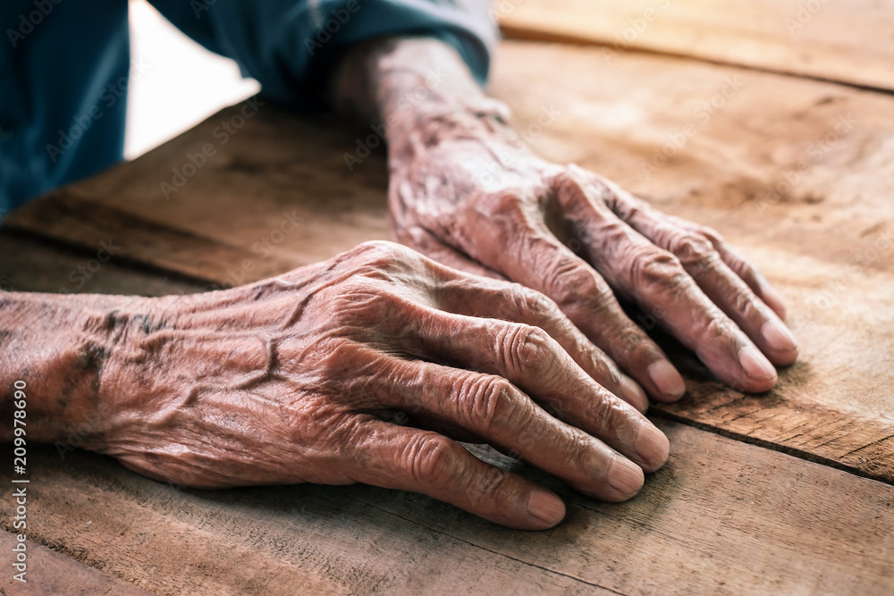Hands of an old man on the wood table.vintage tone Hands of an old man on the wood table.vintage tone