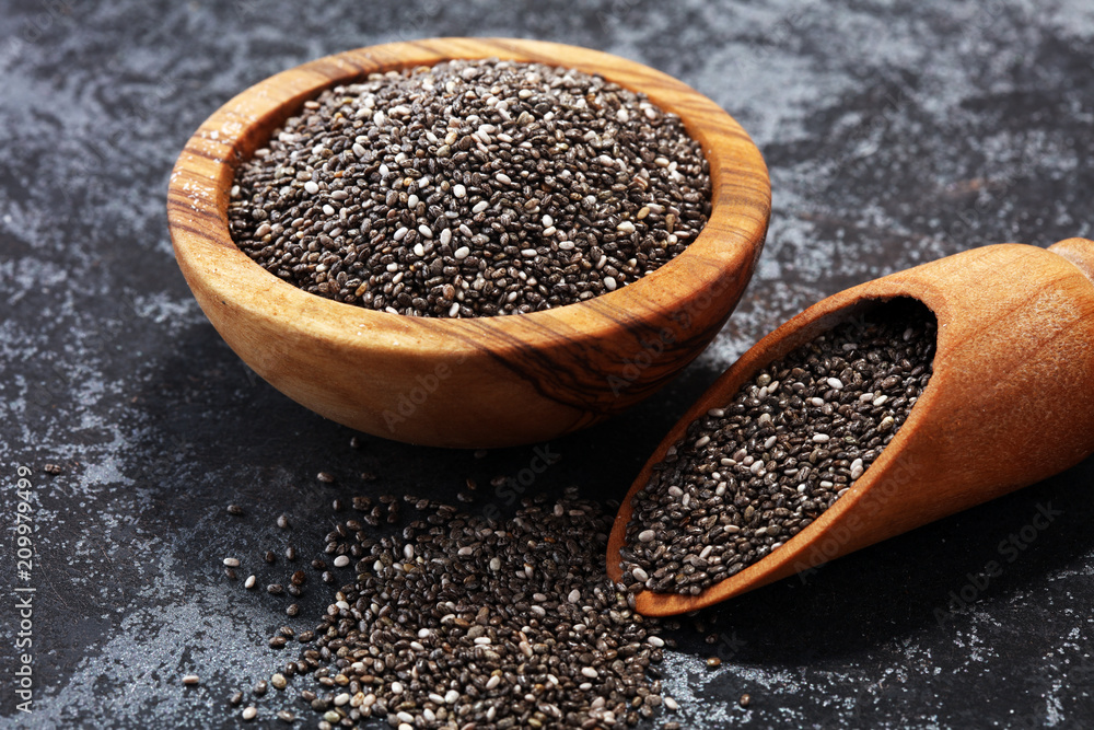 Healthy Chia seeds in a wooden spoon on the table close-up Healthy Chia seeds in a wooden spoon on the table close-up
