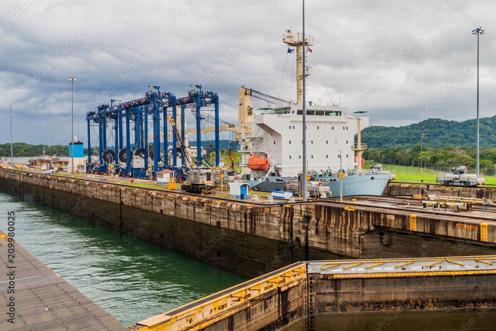 Cargo ship is  passing through Gatun Locks, part of Panama Canal