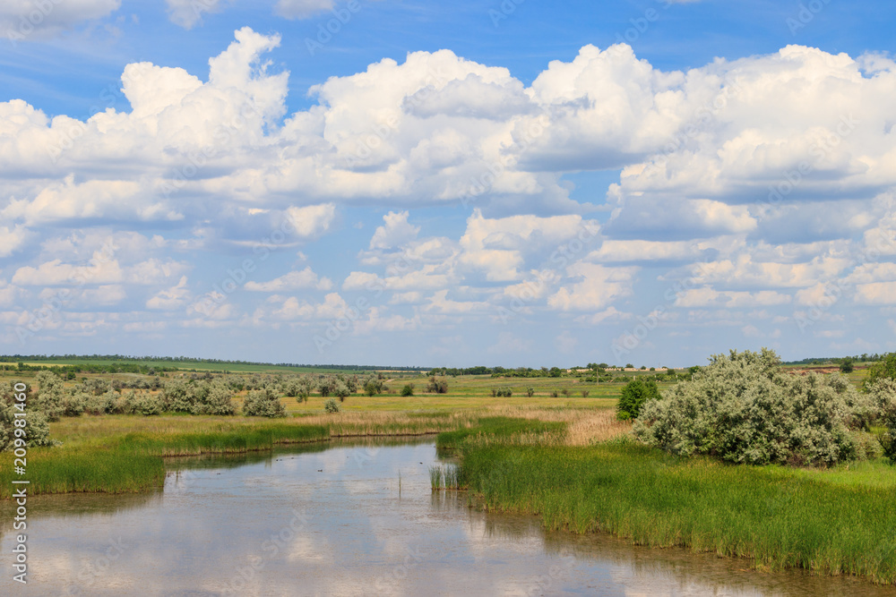 Summer landscape with small river and blue cloudy sky Summer landscape with small river and blue cloudy sky