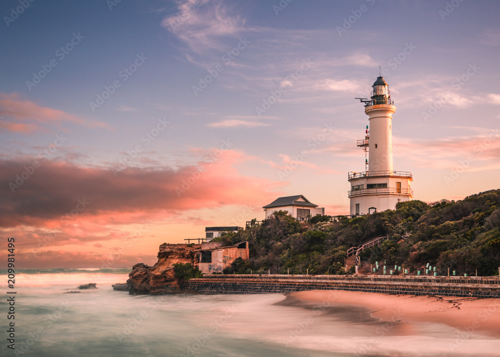 Lighthouse and beach at sunset