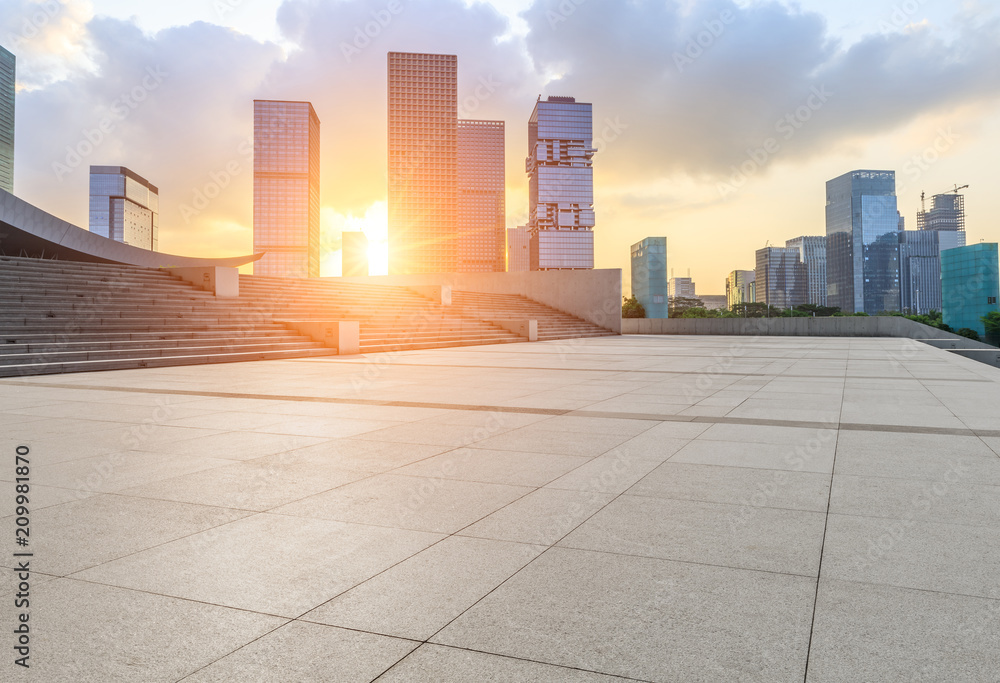 Empty square floor and modern commercial building at sunrise in Shenzhen