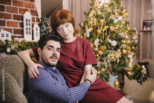 Couple in the living room decorated for Christmas and New Year © keleny