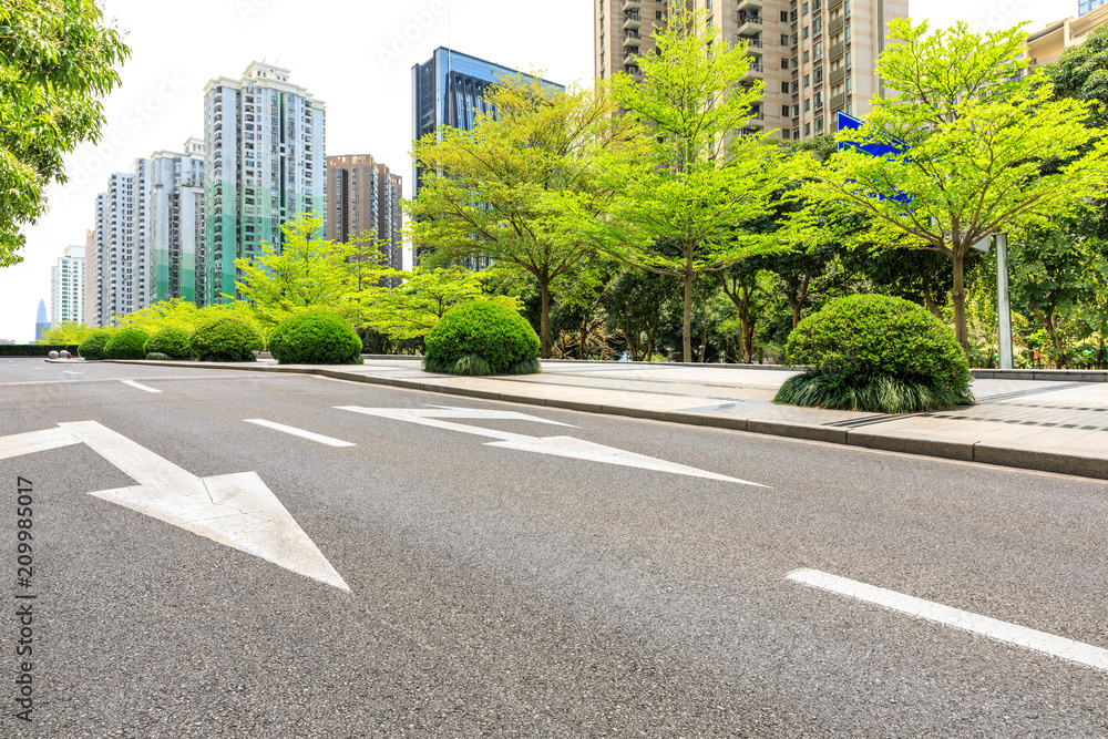 Asphalt road and modern commercial buildings and trees Asphalt road and modern commercial buildings and trees