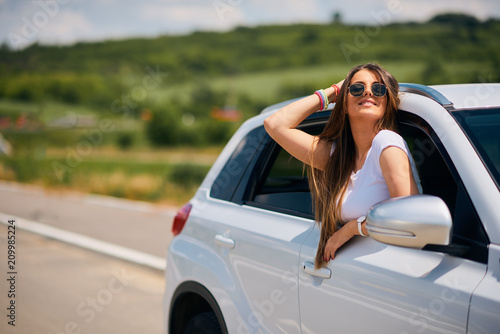 Woman posing while leaning on the car window.