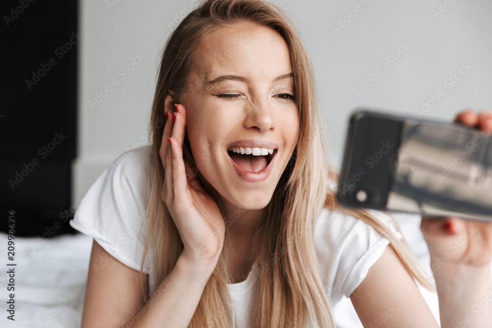 Fototapeta premium Cute beautiful young woman indoors at home make selfie