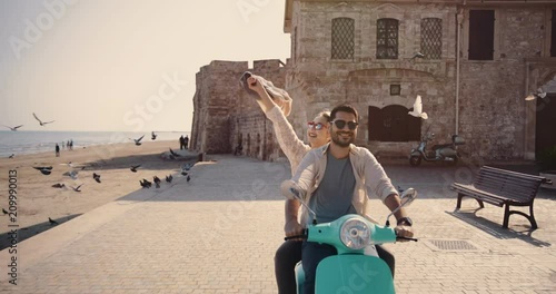 Young tourists couple riding scooter in old European city