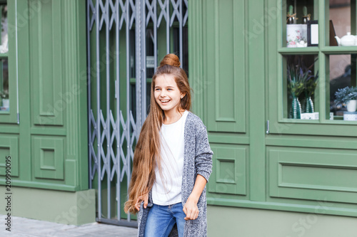 Portrait of a beautiful girl in casual clothing outside french cafe in the street