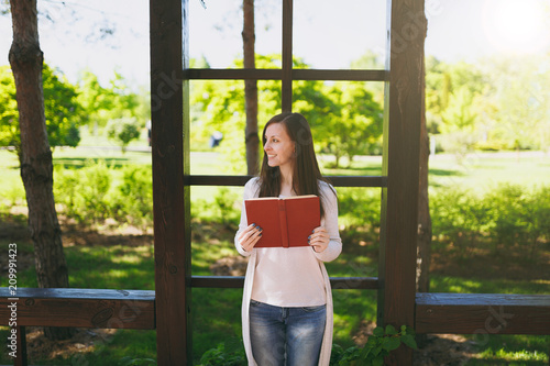 Portrait of beautiful calm peaceful young woman wearing light casual clothes, jeans, relaxing, reading book. Smiling female resting in city park in street outdoors on spring nature. Lifestyle concept. Free Download Portrait of beautiful calm peaceful young woman wearing light casual clothes, jeans, relaxing, reading book. Smiling female resting in city park in street outdoors on spring nature. Lifestyle concept. - GFXLoad