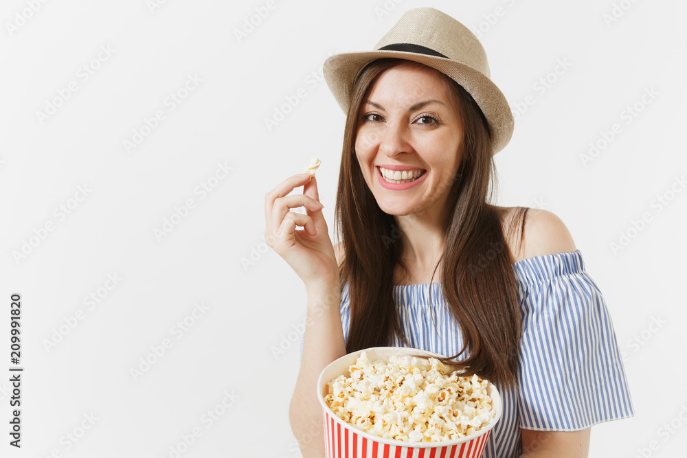Young woman in blue dress, hat watching movie film holding eating popcorn from bucket isolated on white background. People, sincere emotions in cinema, lifestyle concept. Advertising area. Copy space. Young woman in blue dress, hat watching movie film holding eating popcorn from bucket isolated on white background. People, sincere emotions in cinema, lifestyle concept. Advertising area. Copy space.