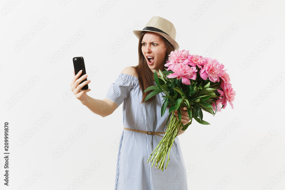 Irritated dissatisfied woman holding bouquet of beautiful pink peonies flowers, doing selfie on mobile phone isolated on white background. St. Valentine's, International Women's Day holiday concept. Irritated dissatisfied woman holding bouquet of beautiful pink peonies flowers, doing selfie on mobile phone isolated on white background. St. Valentine's, International Women's Day holiday concept.