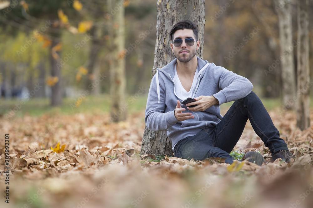 Handsome man in nature taking selfie pictures with his smartphone. Autumn. Copy space Handsome man in nature taking selfie pictures with his smartphone. Autumn. Copy space