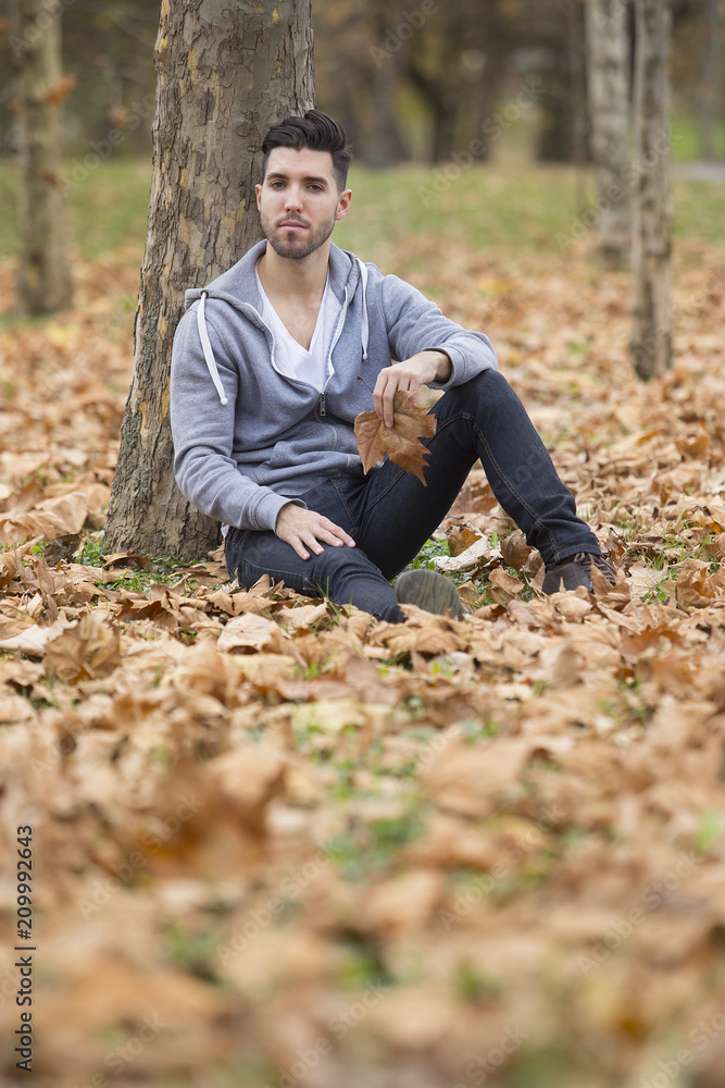 Handsome man in nature holding autumn leaves. Copy space Handsome man in nature holding autumn leaves. Copy space