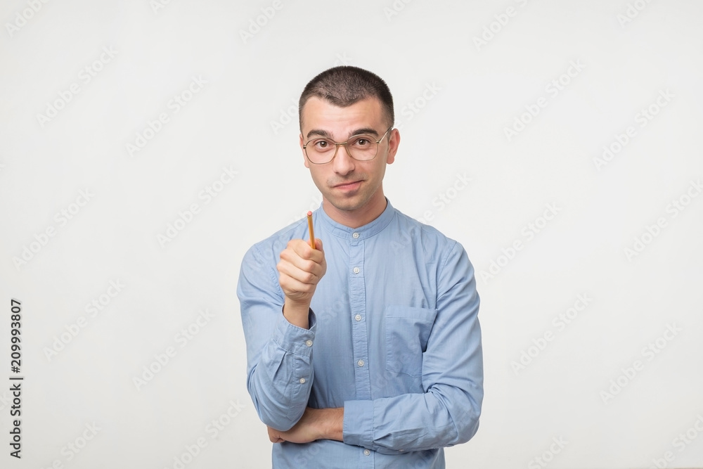 Young man in blue shirt have an idea. He is pointing with pencil on camera. Young man in blue shirt have an idea. He is pointing with pencil on camera.