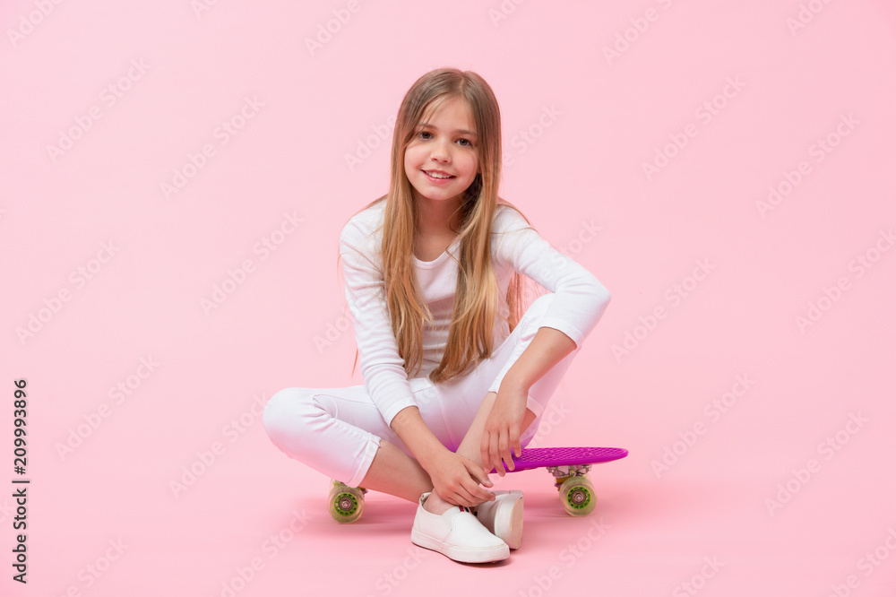 Happy child sit on penny board on pink background. Girl smile with skateboard. Little skater ready to ride. Skateboarding is fun. Active hobby and sport activity, punchy pastel trend. Childhood Happy child sit on penny board on pink background. Girl smile with skateboard. Little skater ready to ride. Skateboarding is fun. Active hobby and sport activity, punchy pastel trend. Childhood
