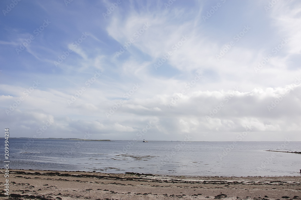 gray waters of the North Sea, deserted beach; coast of Ireland; cloudy sky gray waters of the North Sea, deserted beach; coast of Ireland; cloudy sky