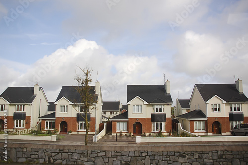 identical cottages, nestled accommodation in a cozy suburb, new municipal residential district densely built over, economy class housing; Ireland