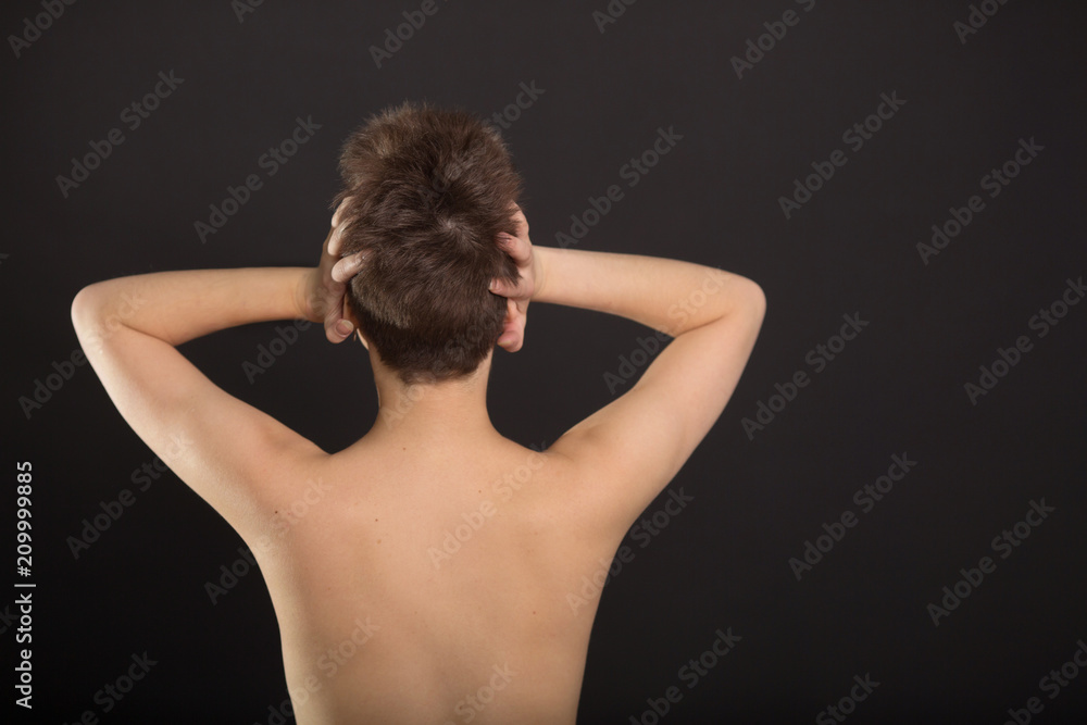 beautiful young girl with short hair with a naked back on a black background beautiful young girl with short hair with a naked back on a black background