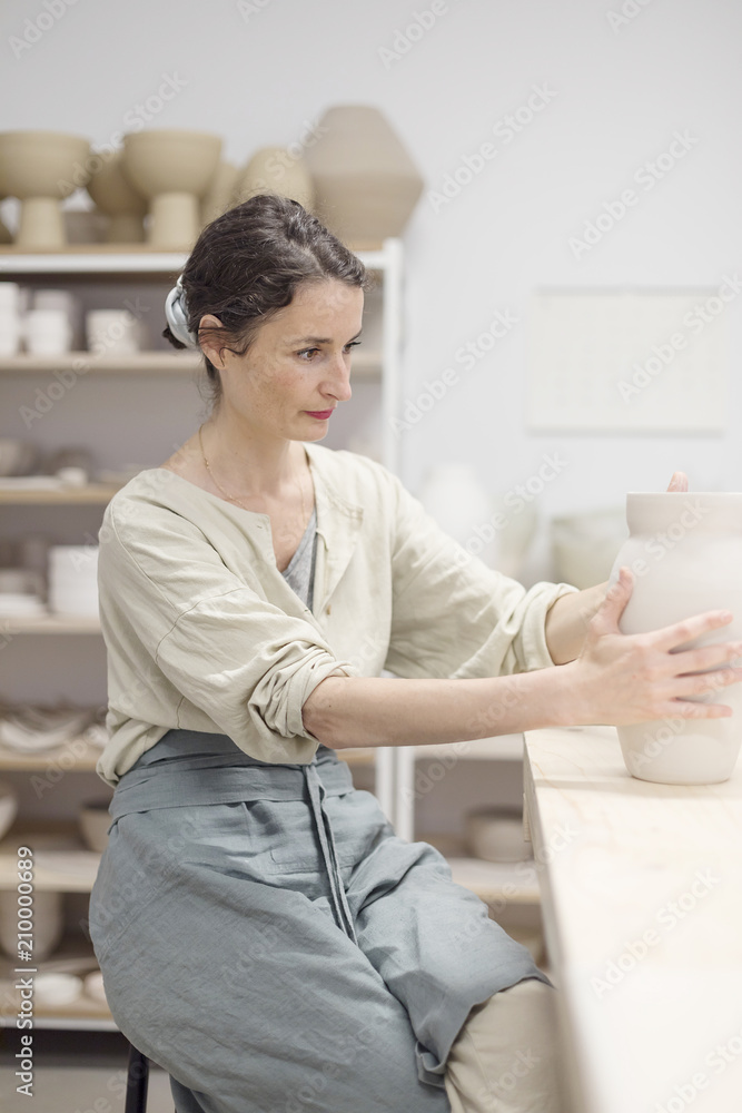 Woman hands makes clay pot on the pottery wheel Woman hands makes clay pot on the pottery wheel