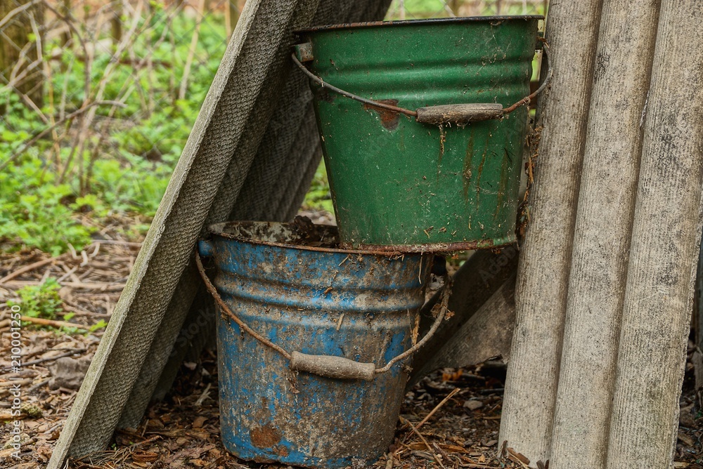 two old dirty buckets in the garden two old dirty buckets in the garden