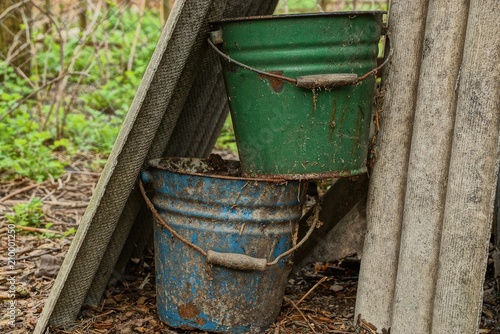 two old dirty buckets in the garden © butus