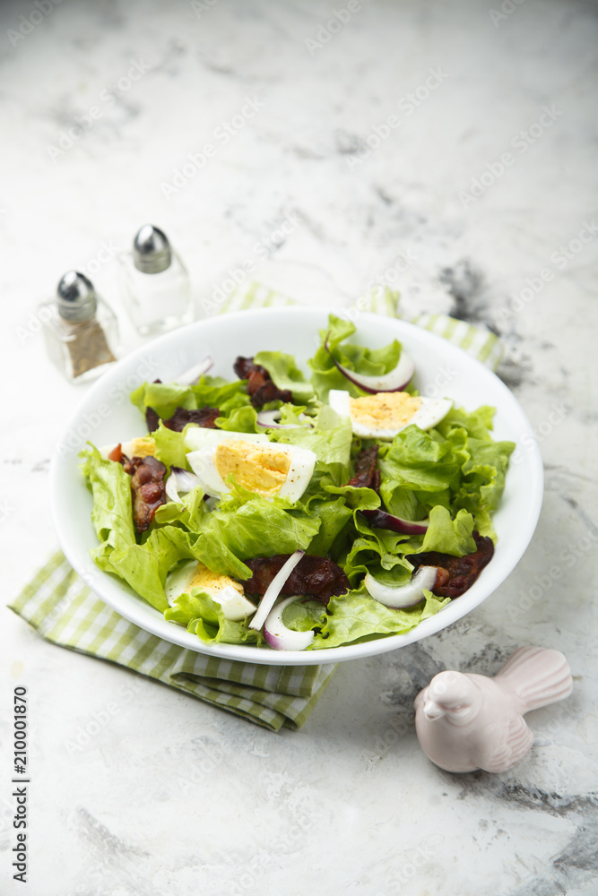 Lettuce salad with fried bacon, red onion and hard boiled egg Lettuce salad with fried bacon, red onion and hard boiled egg