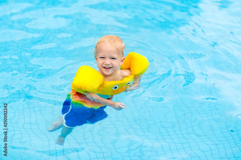 Baby in swimming pool. Kids swim.